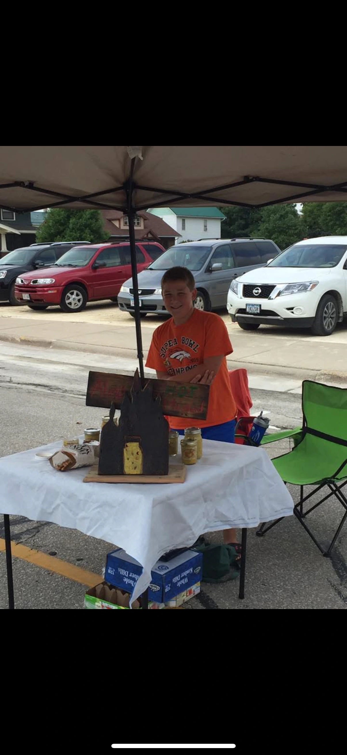 Alex, age ten, selling homemade mustard at a Saturday farmers market stand